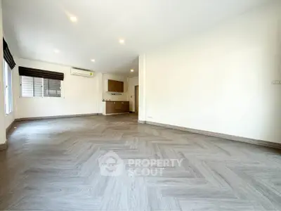 Spacious open-plan living room with modern flooring and ample natural light