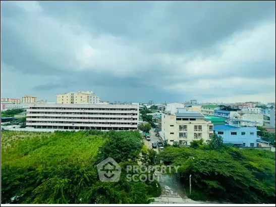 Stunning cityscape view with lush greenery and modern buildings under a dramatic sky.