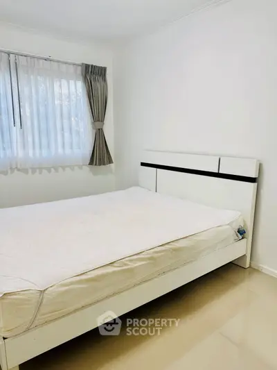 Bright and cozy bedroom with modern white bed and large window