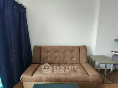 Cozy living room with brown sofa and blue curtains, perfect for relaxation.