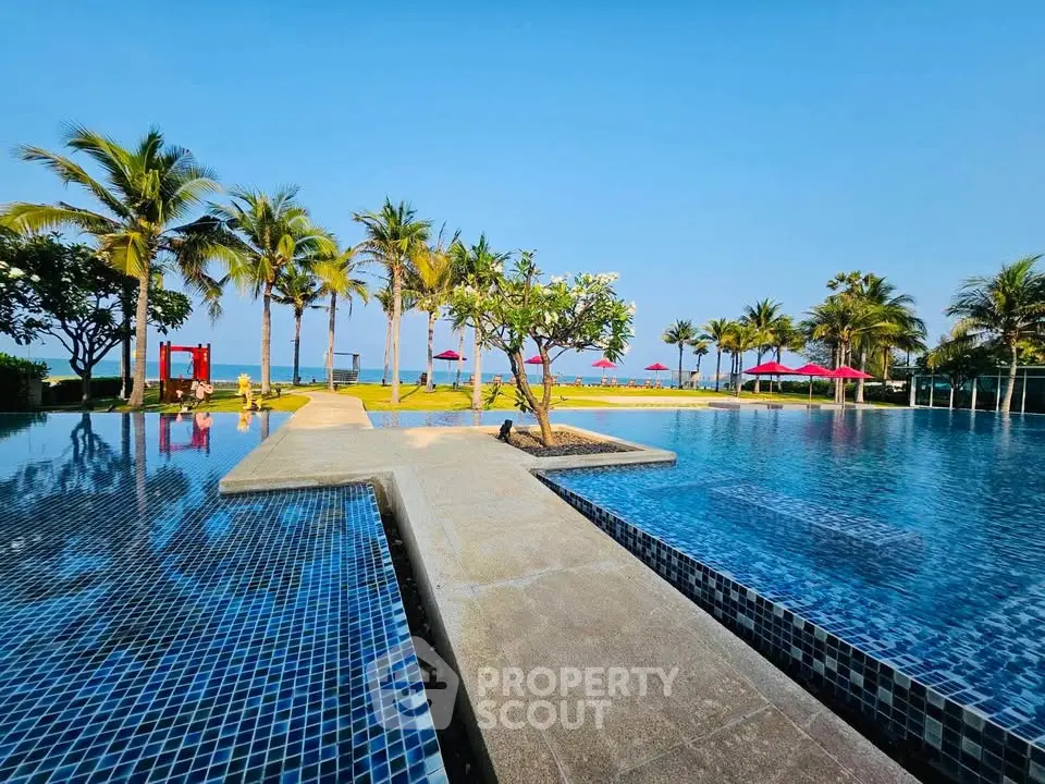 Luxurious beachfront pool with stunning ocean view and palm trees