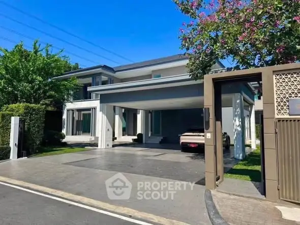 Stunning modern house with spacious driveway and lush greenery, perfect for luxurious living.