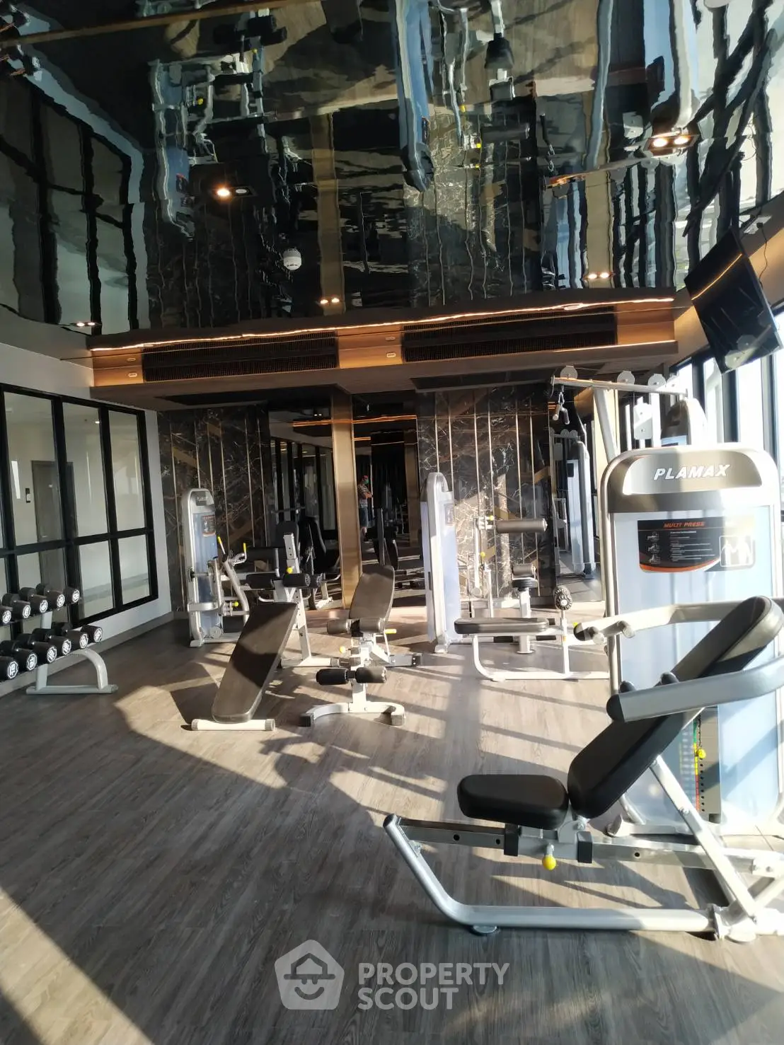 Luxurious gym with modern equipment and sleek design in upscale residential building.