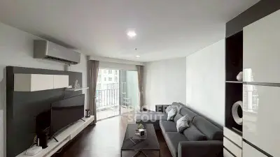 Modern living room with sleek furniture and balcony access in urban apartment.