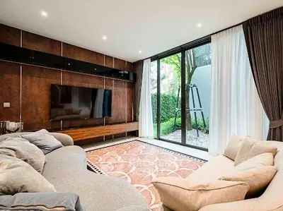 Luxurious living room with large TV and garden view, featuring modern decor and cozy seating.