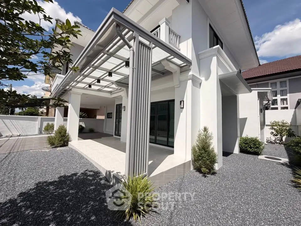 Elegant modern house exterior with spacious patio and lush landscaping under a clear blue sky.