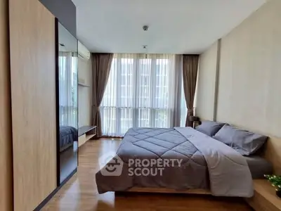 Spacious modern bedroom with large windows and elegant decor in a luxury apartment.
