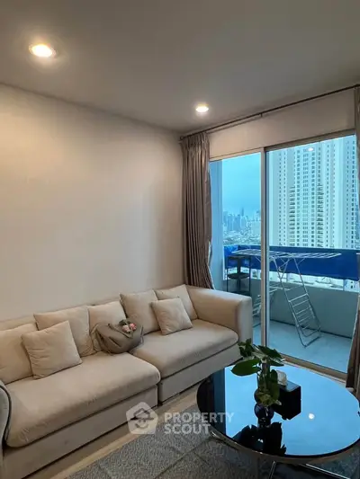 Modern living room with city view and balcony access, featuring a cozy sofa and stylish decor.