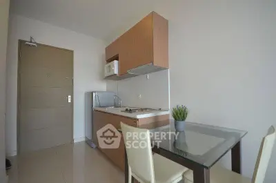 Modern compact kitchen with sleek cabinetry and dining area in a cozy apartment.