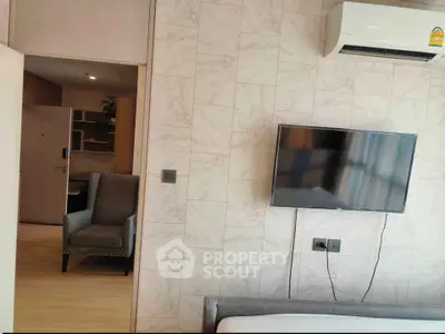 Modern bedroom with wall-mounted TV and air conditioning unit