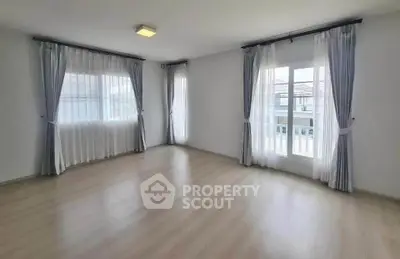 Spacious empty room with large windows and elegant curtains, perfect for customization.
