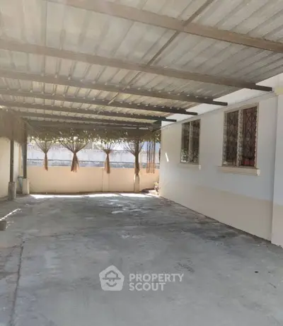 Spacious covered parking area with metal roof and natural light