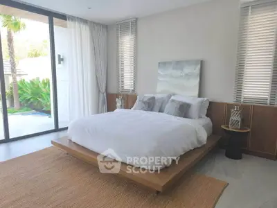 Luxurious bedroom with modern decor and garden view in a serene real estate property.