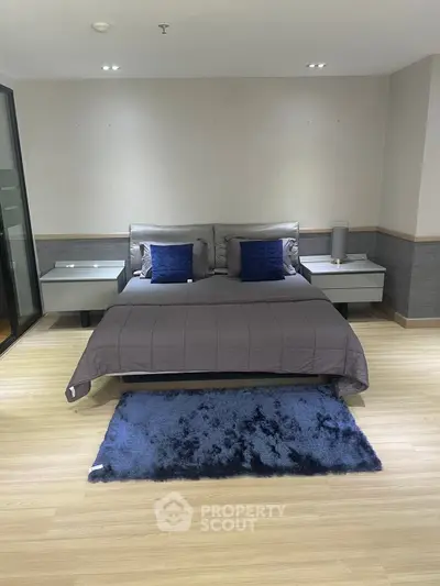 Modern bedroom with stylish decor and cozy bedding in a contemporary apartment.