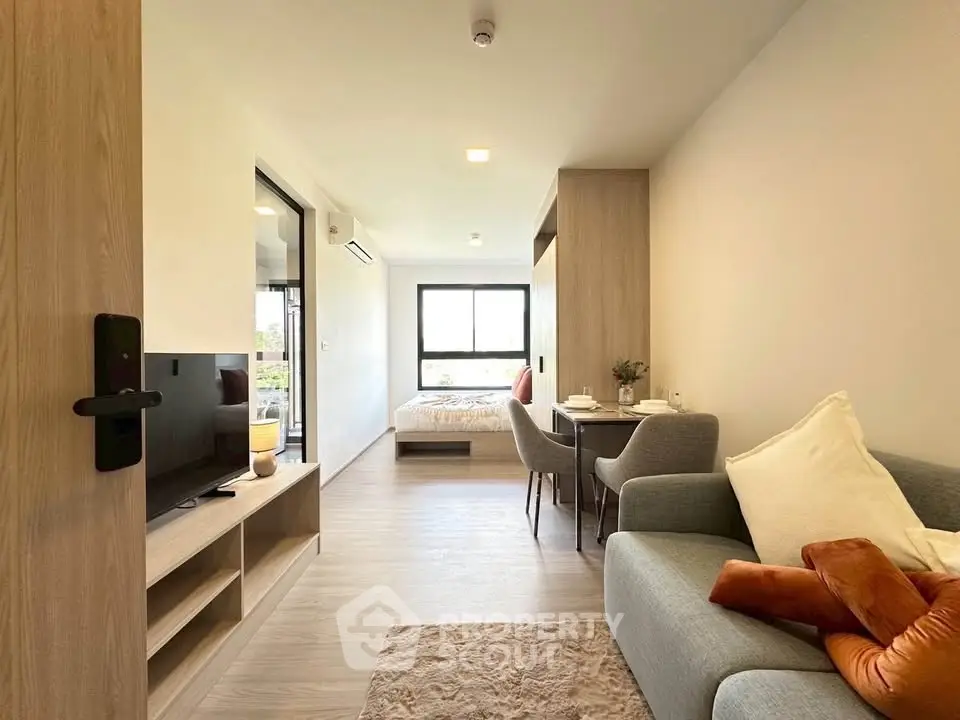 Modern open-plan living room with cozy seating and natural light in a stylish apartment.