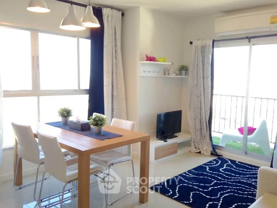 Bright modern living room with dining area and balcony access, featuring stylish decor and ample natural light.