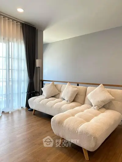 Modern living room with stylish beige sofas and wooden flooring