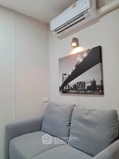 Cozy living room with modern gray sofa and stylish wall art