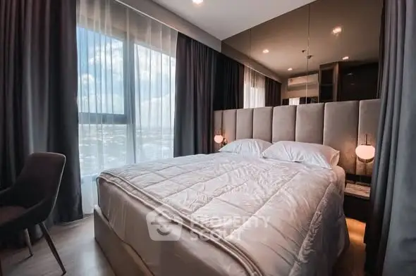 Luxurious bedroom with plush bedding and floor-to-ceiling windows offering stunning views.