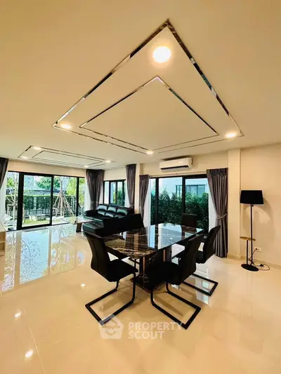 Spacious modern living room with elegant dining area and large windows offering garden views.