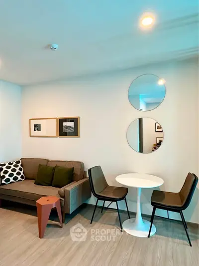 Modern living room with stylish furniture and wall decor, featuring a cozy sofa and chic dining area.