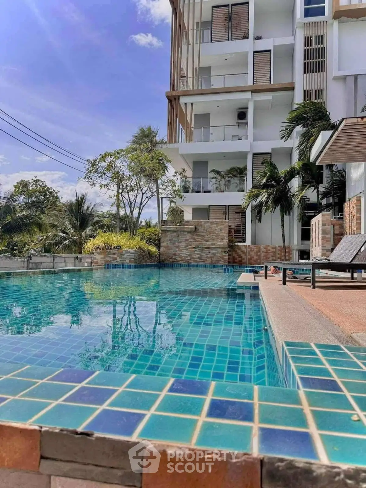 Luxurious apartment building with stunning pool and lush greenery