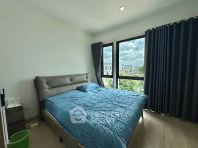 Spacious bedroom with large window offering scenic view and natural light