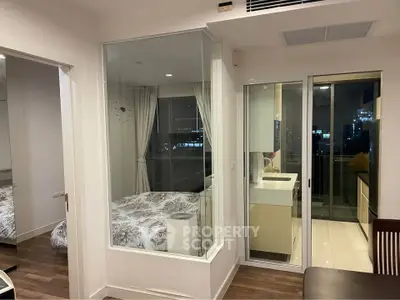 Modern apartment interior with glass-walled bedroom and city view balcony.