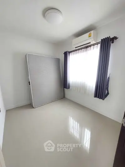 Spacious empty bedroom with air conditioning and natural light