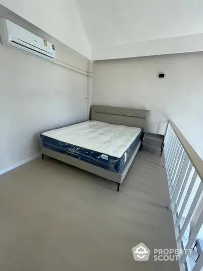 Modern bedroom with minimalist design and air conditioning in a loft-style apartment