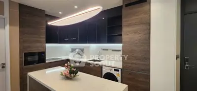 Modern kitchen with sleek cabinetry, island, and built-in appliances in a stylish apartment.