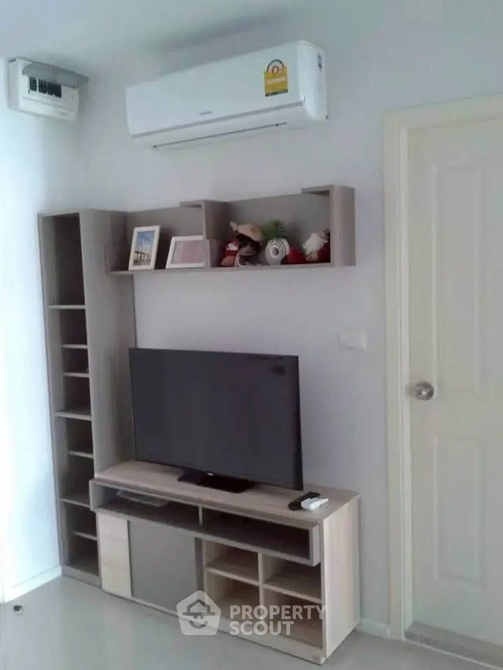 Modern living room with sleek TV stand and wall-mounted air conditioner, perfect for comfortable living.