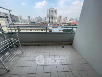 Spacious balcony with city skyline view, perfect for relaxation and enjoying urban living.