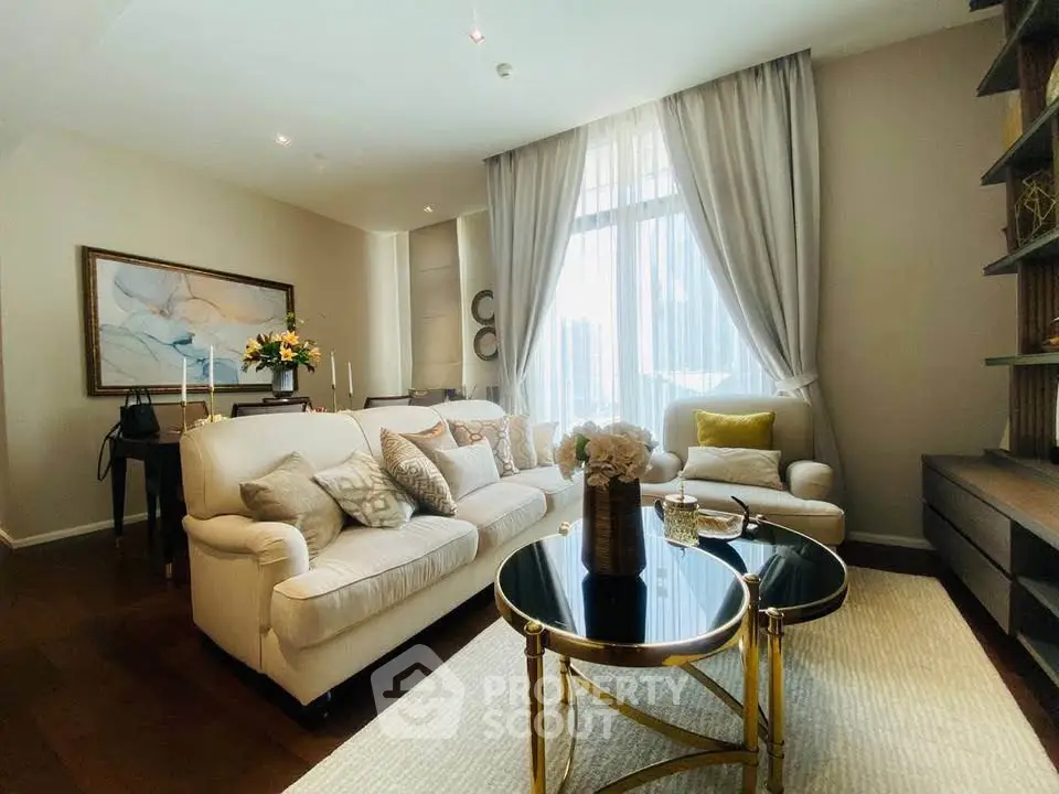 Luxurious living room with elegant decor and large window, featuring plush seating and stylish accents.