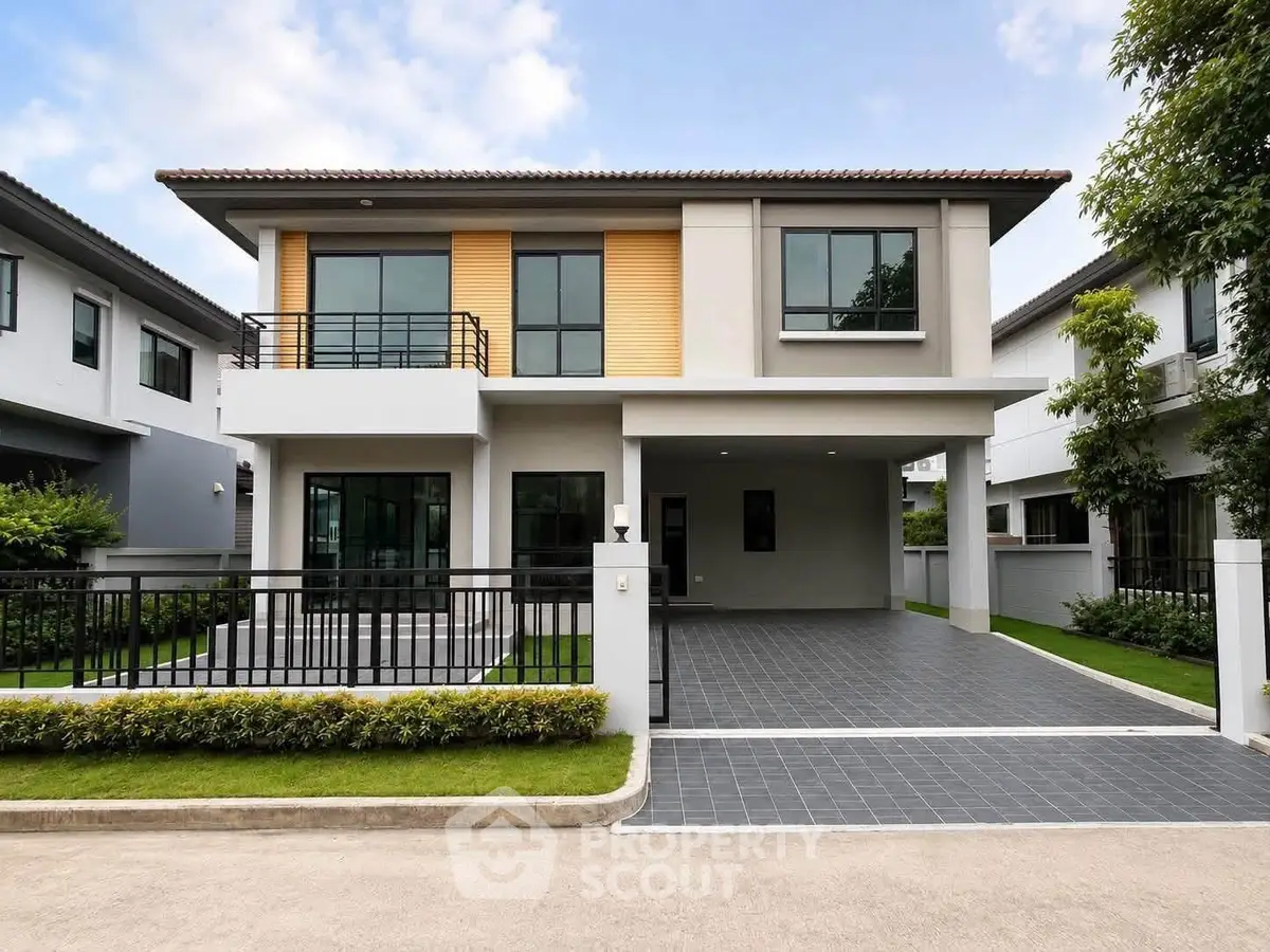 Modern two-story house with sleek design and spacious driveway in a suburban neighborhood.