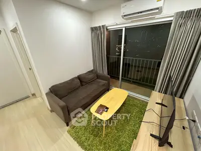 Cozy living room with balcony view, featuring a comfortable sofa and modern decor.
