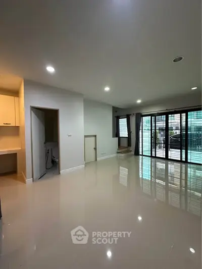 Spacious modern living room with large windows and sleek flooring