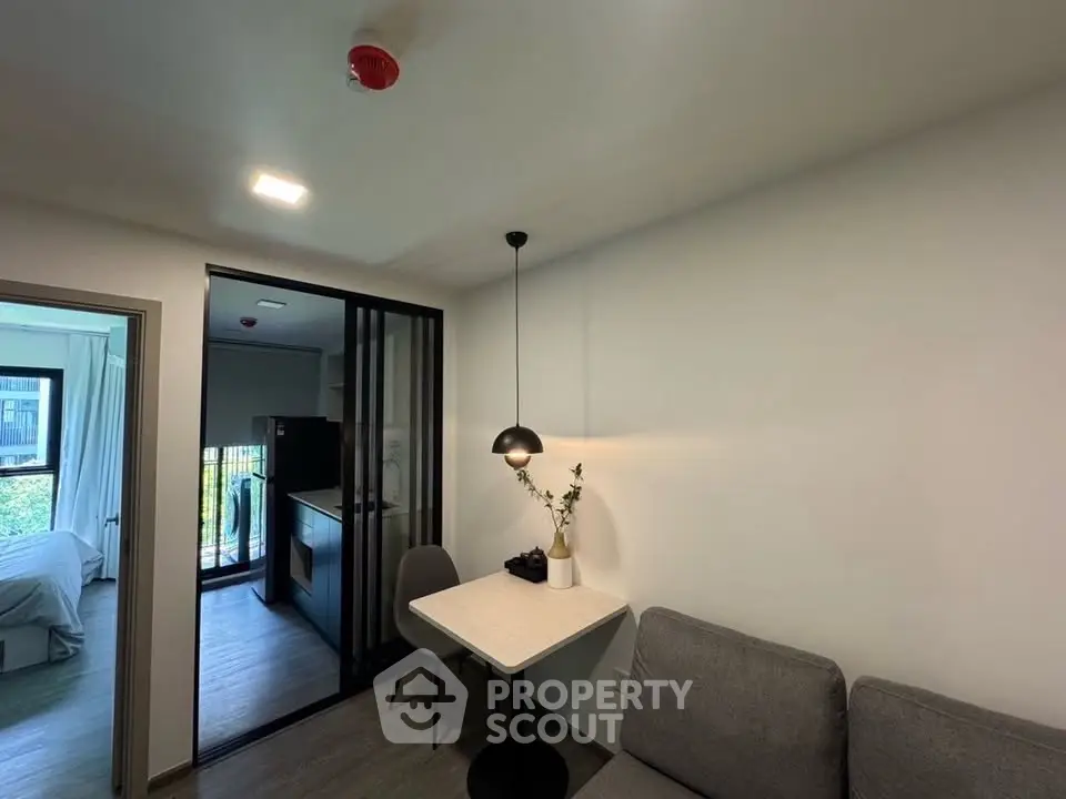 Modern apartment interior with cozy dining area and view into bedroom and kitchen.