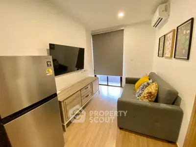 Modern living room with sleek furniture and wall-mounted TV in a cozy apartment.