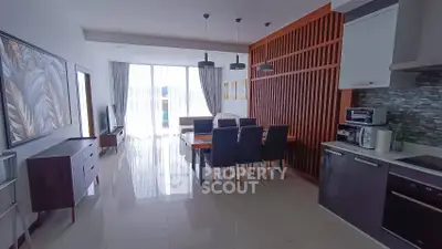 Spacious modern living room with dining area and open kitchen, featuring stylish decor and natural light.