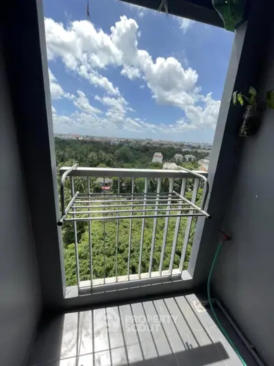 Stunning balcony view with lush greenery and clear blue skies, perfect for relaxation and enjoying nature.