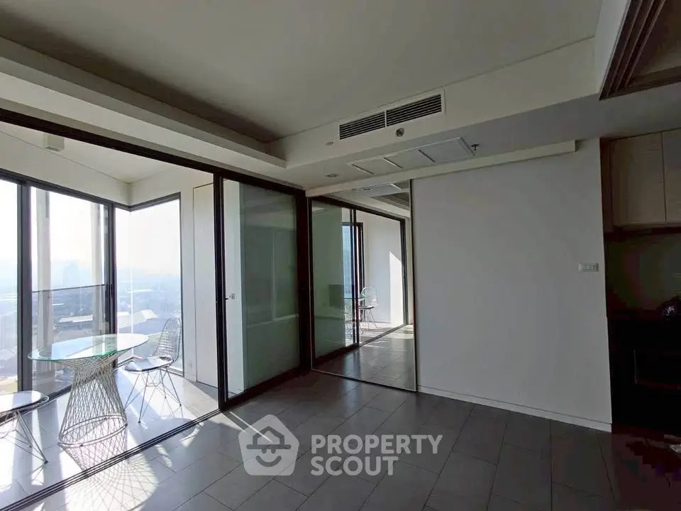 Spacious modern apartment with floor-to-ceiling windows and stunning city view.