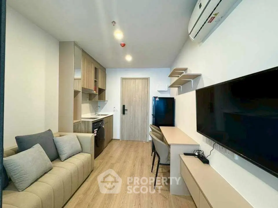 Modern living room with sleek furniture and built-in appliances in a cozy apartment.