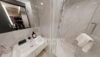 Modern bathroom with sleek shower and elegant sink in luxurious apartment.