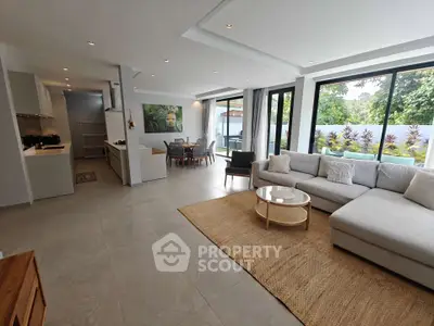 Spacious modern living room with open layout and garden view, featuring elegant furniture and natural light.