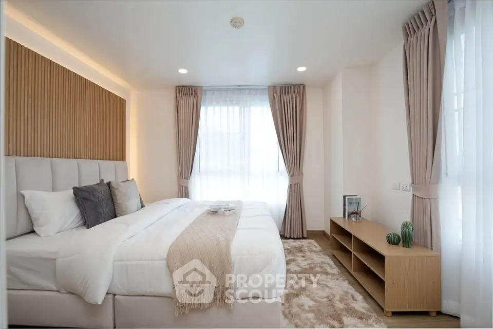 Elegant bedroom with cozy decor and natural light, featuring plush bedding and stylish curtains.