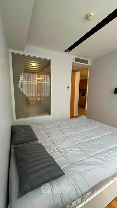 Modern bedroom with sleek design and cozy bedding in a contemporary apartment.