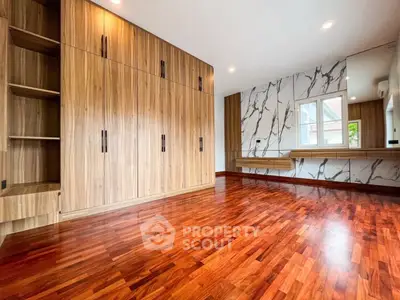 Spacious bedroom with elegant wooden flooring and built-in wardrobe