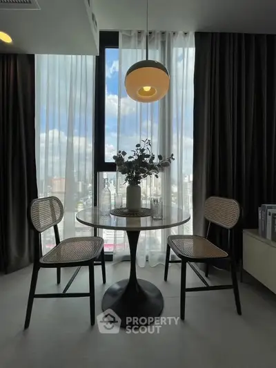 Chic dining area with modern table and chairs, large window with city view, and elegant lighting.