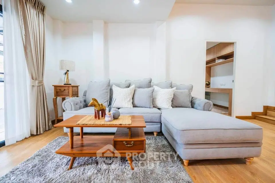 Spacious living room with elegant gray sectional sofa and wooden coffee table.